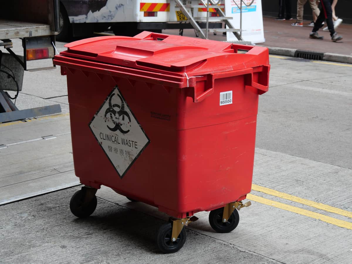 Wheeled outdoor trash cart beside a house