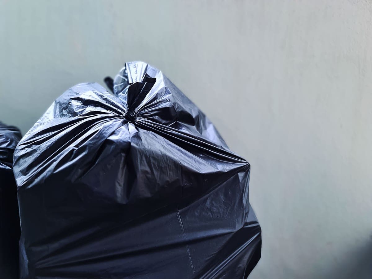 Roll of black trash bags beside a tape measure